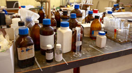 Prescription vials and liquid medicine bottles on stainless steel table
