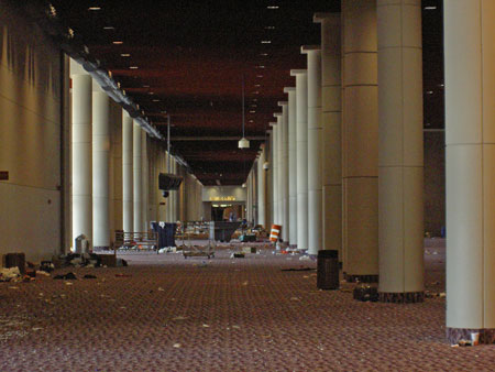 Building interior with large white columns and debris on red carpet